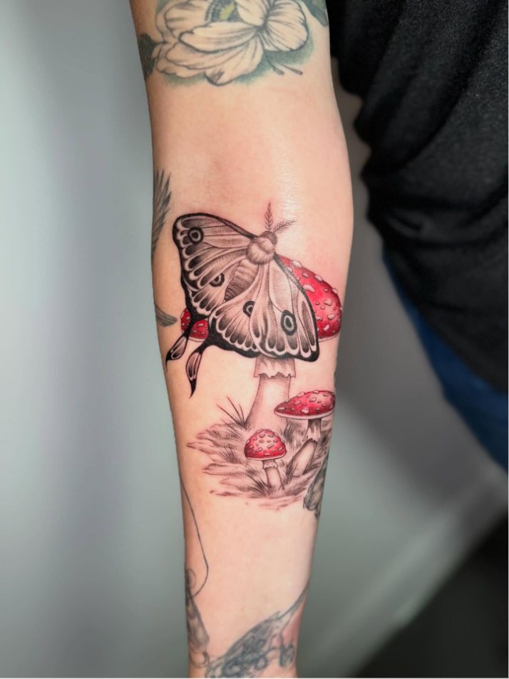 Moth on a mushroom forearm tattoo